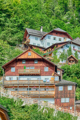 Obraz premium Wooden and rendered alpine houses with bright pastel-colored painted exteriors and lush plant and flower boxes outside windows at the UNESCO Heritage listed village of Hallstatt, Austria, Europe