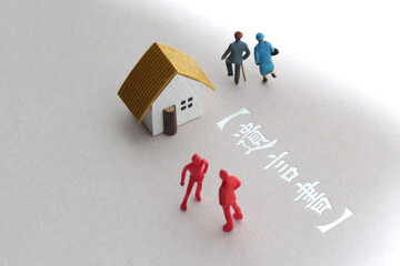 遺産相続のトラブルをミニチュア人形と家と文言で表現した写真