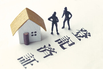 遺産相続のトラブルをミニチュア人形と家と文言で表現した写真