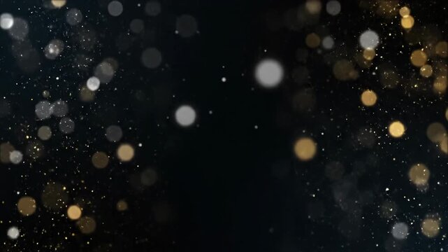 Abstract golden and silver bokeh lights shimmering and floating against a deep black background, creating an elegant and festive defocused composition.