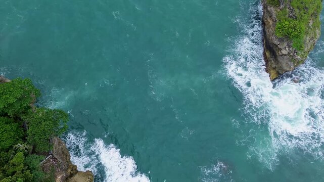 Top Down Drone View of Ocean Waves Crashing on Rocky Coast, Ngliyep Beach Indonesia