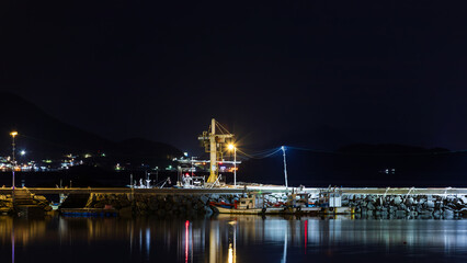Harbor Breakwater at Night with Moored Boats and Pier Lights