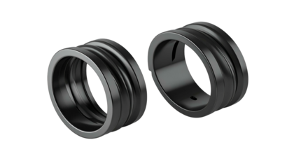 Two dark, metallic rings with grooved textures, possibly jewelry, against a black background
