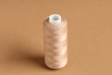 Spool of thread on brown background