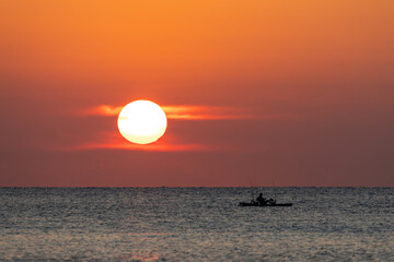 Silhouette of Kayak Fisherman at Sunrise Over Calm Ocean