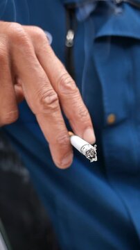 Smoking a cigarette while resting on a street corner