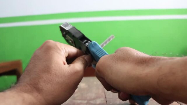 Network technician stripping and splicing local area network cables for internet