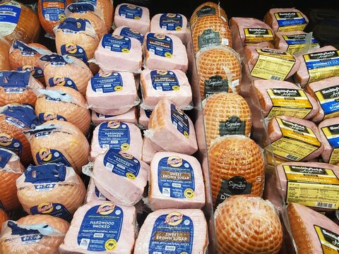 Delaware, U.S - Dec 13, 2025 - Packaged hams in various flavors and brands line the grocery shelf, showcasing smoked, sweet, and roasted options.