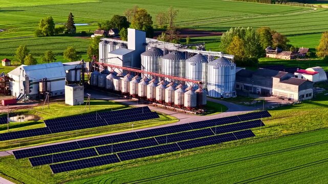 Aerial view of grain storage containers and factory powered by clean green solar energy.