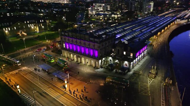 4K cinematic drone footage of Heuston Station in Dublin at sunset, highlighting the historic building, approaching trains, and the Dublin skyline under dramatic sunset hues. Dublin_033