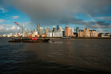 Fototapeta premium London canary wharf cityscape with working crane and rainbow