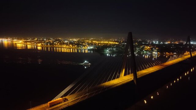 Aerial night orbit of the San Roque Gonz&aacute;lez de Santa Cruz Bridge, a cable-stayed road and rail span linking Posadas, Misiones, Argentina with Encarnaci&oacute;n, Itap&uacute;a, Paraguay across the Paran&aacute; River.