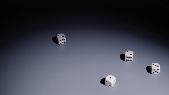 Slow-motion wide shot as four dice roll from screen right to middle and stop.