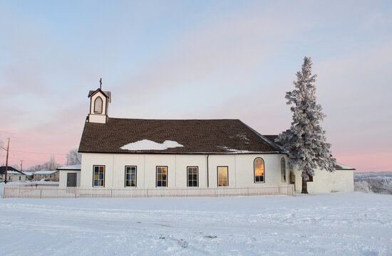 Iglesia con ventanas rectanmgulares y pino nevado