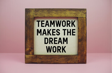 Wooden framed with motivational quote "TEAMWORK MAKES THE DREAM WORK" displayed against a pink background