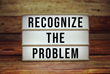 Lightbox with text "Recognize The Problem" on wooden background