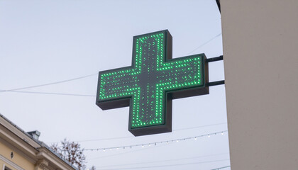 A neon sign on a building symbolizes a pharmacy.