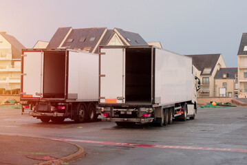 Rear View of Two Empty Box Trucks Parked in a Residential Area Near The Warehouse