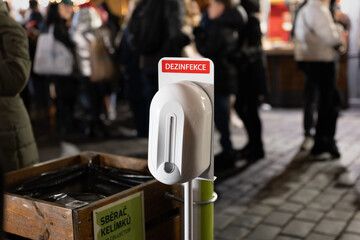 Disinfection (Dezinfekce) at the Christmas market in Prague, Czech Republic. Disinfectant dispenser...