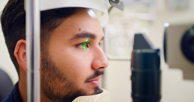Man, eye exam and lamp machine for optometry inspection, laser correction and cornea procedure. Male person, equipment and light for ophthalmology assessment, retinal evaluation and testing eyesight