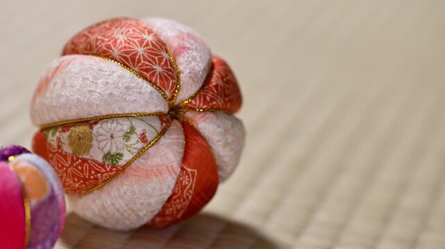 Traditional Japanese Temari Ball Gently Rolling on Tatami Mat