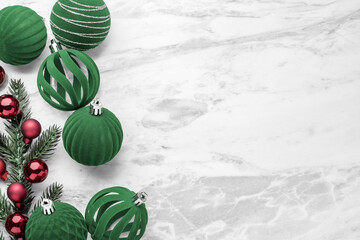 Christmas ball decor, green velvet bauble and pine branches on marble table background, top view