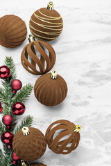 Christmas ball decor, brown velvet bauble and pine branches on marble table background