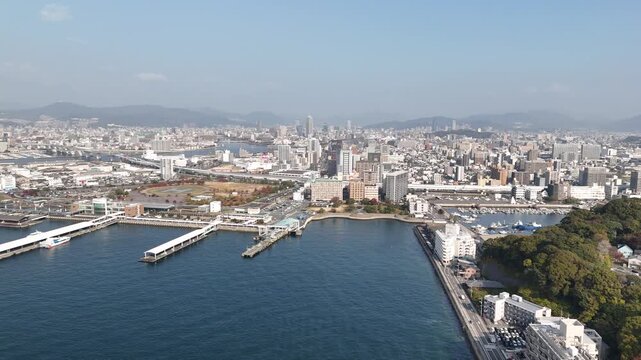 Hiroshima Port, Japan: 4K Aerial Drone Footage of Ferry Terminal, City Skyline, Hiroshima Bay, Harbour Infrastructure, Coastal Mountains and Waterfront Urban Landscape, Ujina Island and Kanawa Island