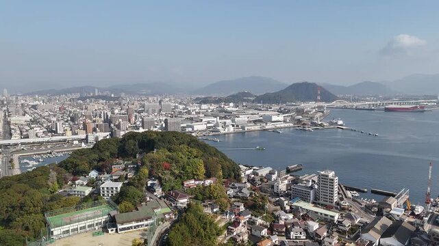 Hiroshima Port, Japan: 4K Aerial Drone Footage of Ferry Terminal, City Skyline, Hiroshima Bay, Harbour Infrastructure, Coastal Mountains and Waterfront Urban Landscape, Ujina Island and Kanawa Island