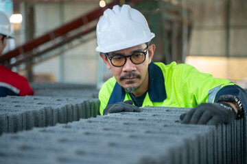 A quality assurance specialist scrutinizing the alignment and surface texture of the concrete block rows to ensure uniformity.