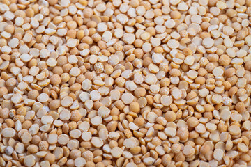 Closeup scattered yellow split peas texture, visual for artisan miller planning smallbatch milling, warm natural light, shallow depth of field, rustic edible ingredient focus