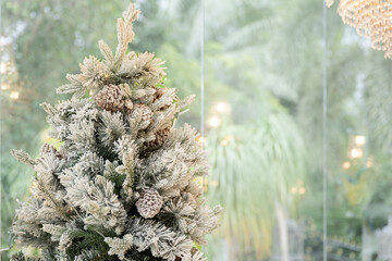 Blue Christmas tree with snowflakes falling on its branches