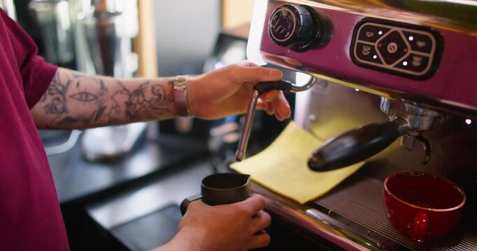 Steaming milk. Using cappuccino machine. Barista turning knob for frothing cream in metal pitcher. Worker professionally preparing hot latte.