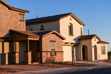 Newly completed stucco two-story homes in a residential subdivision, illustrating modern housing development, finished exterior construction, and suburban homebuilding activity