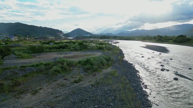 A ground-level aerial beside the Chico River captures its steady flow through rocky banks and lush terrain in Bontoc, Nueva Vizcaya, Philippines