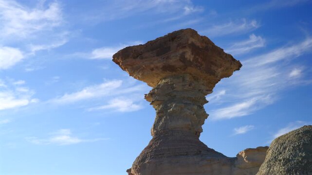 Iconic El Hongo rock formation rising in Ischigualasto Provincial Park, Argentina, shaped by wind erosion in a desert landscape.