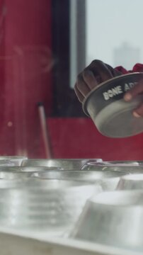 Food, hands and volunteer in animal shelter for feeding, charity or dog nutrition for growth in kennel. Health, bowls and man ngo worker at foster sanctuary for diet or pet care at adoption center.