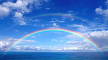 Fototapeta premium Two stunning rainbows stretch across the sky creating a magical scene above the calm ocean.