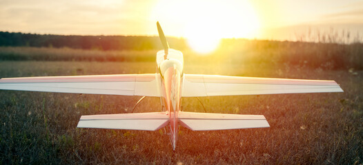 Model airplane on a field during sunset