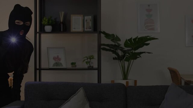 Masked Female Intruder with Flashlight in Cozy Living Room