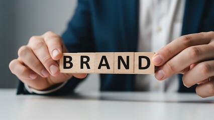 A business professional holding wooden blocks that spell out the word brand