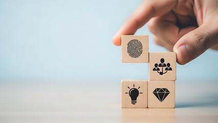A hand stacking wooden blocks with various symbols