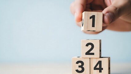 A hand stacking wooden number blocks in ascending order