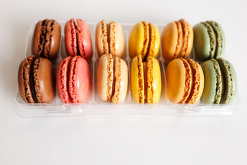 Close up colorful macarons in plastic tray dessert background
