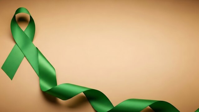 A flowing emerald green satin ribbon curled and dd against a warm, neutral beige background, symbolizing awareness and support.
