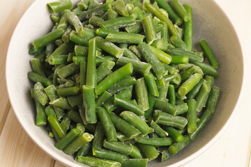 Frozen sliced green beans in a ceramic bowl. Perfect for healthy cooking intros, ingredient shots, and vegetarian recipe