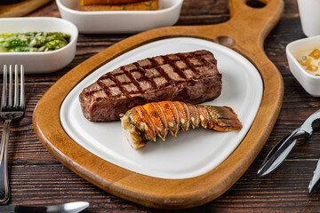 Sirloin steak served with grilled lobster tail and green puree