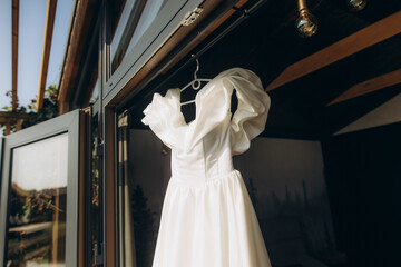 White wedding dress hanging for bridal preparation