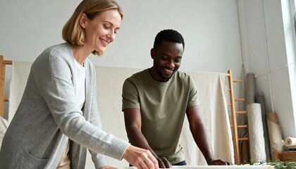 Diverse colleagues smiling and working together in a creative studio. Man and woman collaborating on a design project. Small business teamwork and entrepreneurship concept