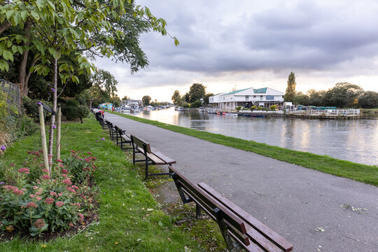Riverside benches along the Thames at Queen&rsquo;s Promenade in Surbiton, London, with Raven&rsquo;s Ait island